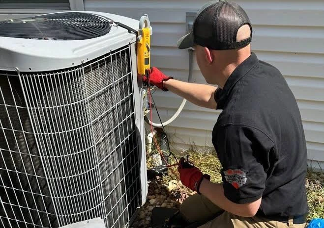 Technician using a meter to troubleshoot an outdoor air conditioning system