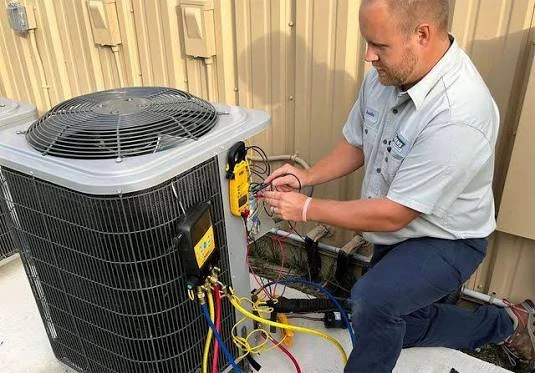 Technician measuring the performance of an outdoor cooling system
